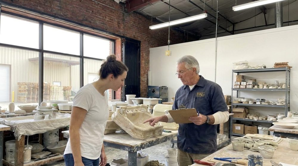 Kevin Tolbert in his restoration workshop examining a piece of antique porcelain